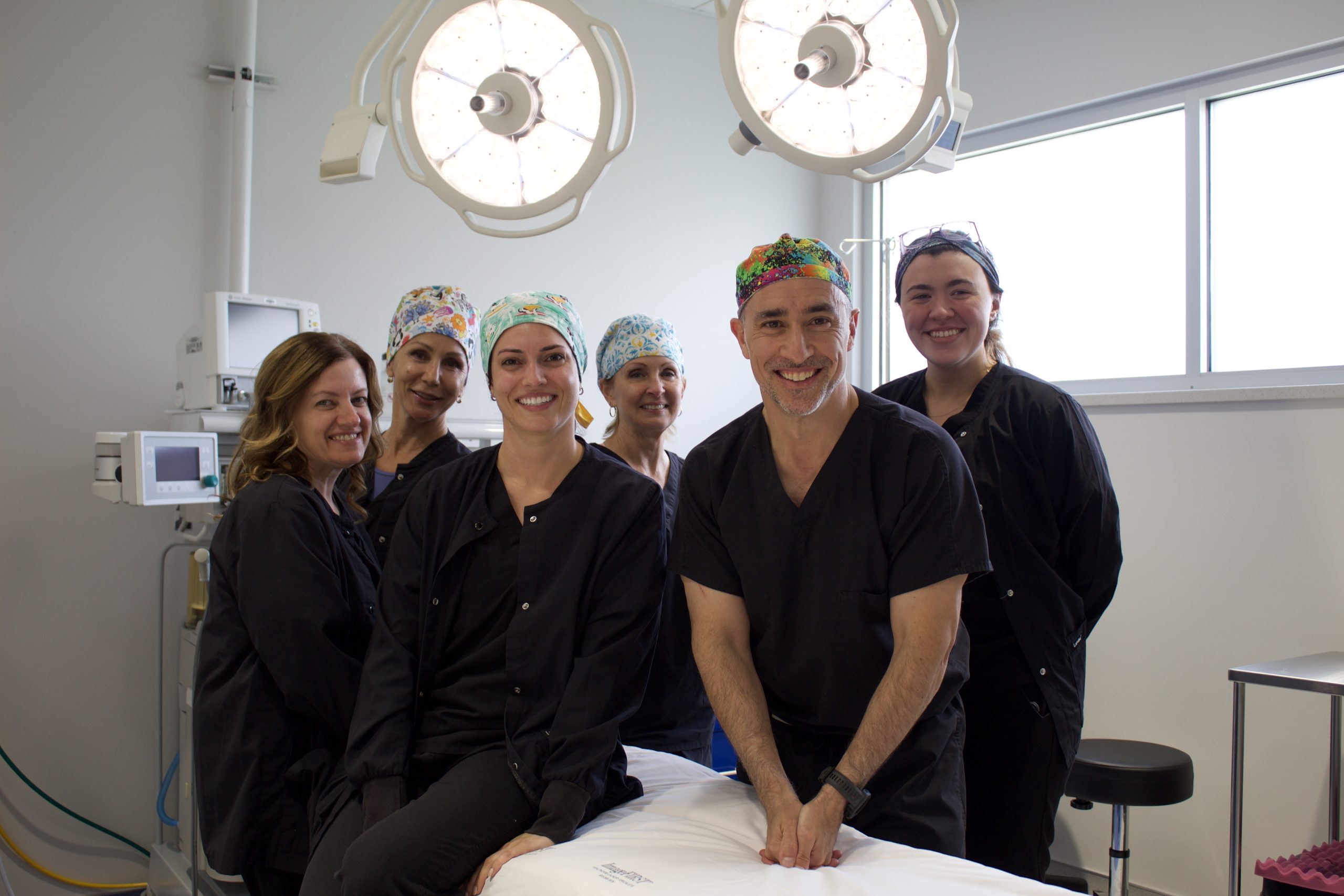 Dr. Goldman and the Beachwood Plastic Surgery team smiling together in the operating room.